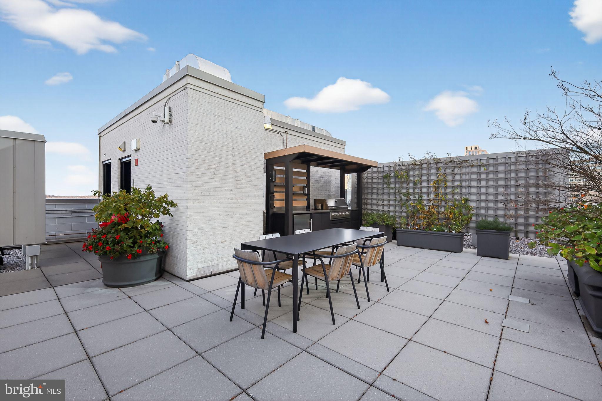 12025 New Dominion Parkway, Unit 311 Reston, VA 20190 - Photo 29 of 29 a view of a patio with table and chairs and potted plants