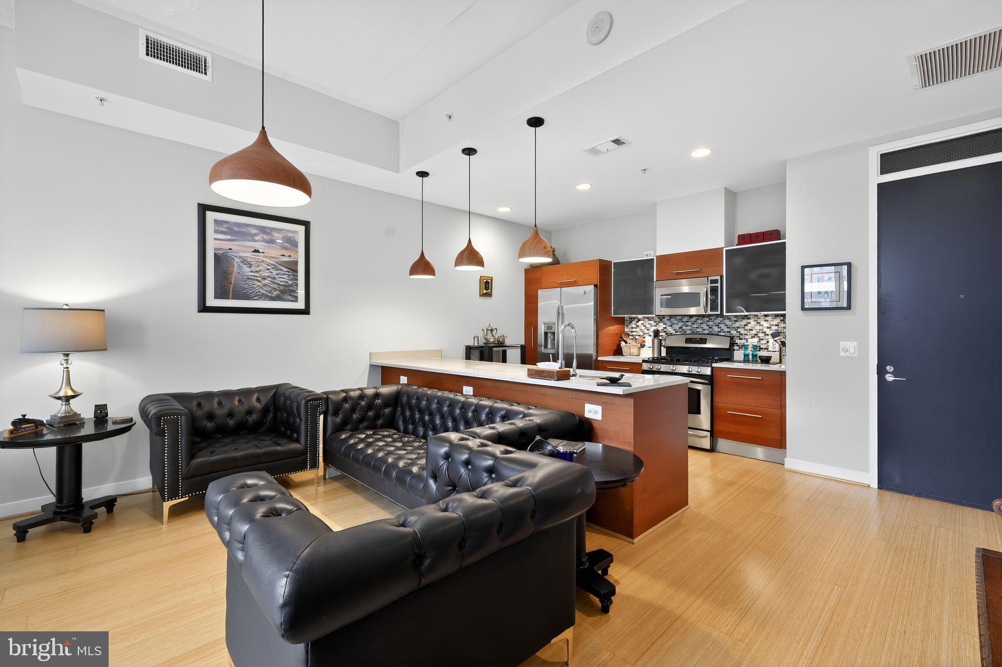 12025 New Dominion Parkway, Unit 311 Reston, VA 20190 - Photo 9 of 29 a kitchen with stainless steel appliances granite countertop a refrigerator a stove a sink dishwasher a dining table and chairs with wooden floor