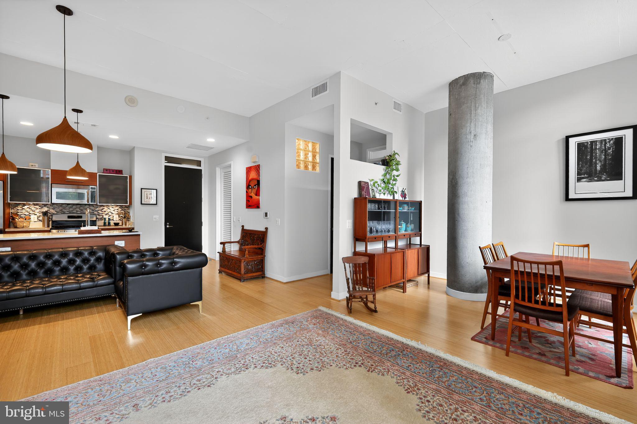 12025 New Dominion Parkway, Unit 311 Reston, VA 20190 - Photo 10 of 29 a living room with furniture and a dining table with wooden floor