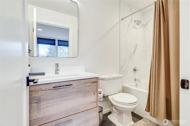 a bathroom with a toilet sink vanity and mirror