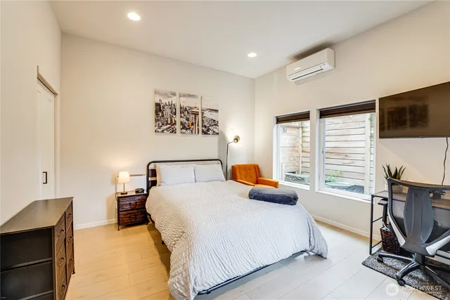 a bedroom with a bed a couch and a flat screen tv