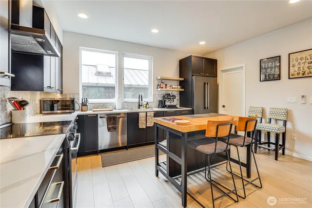 a kitchen with stainless steel appliances granite countertop counter space a sink and a refrigerator