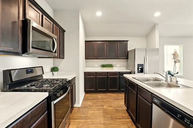 a kitchen with stainless steel appliances granite countertop a stove a sink and a microwave