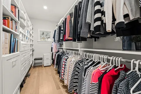 a view of walk in closet with clothes and shoes