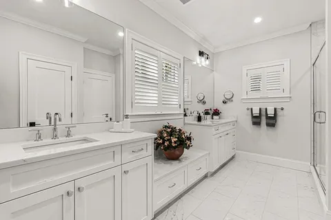 a bathroom with a double vanity sink window and flower