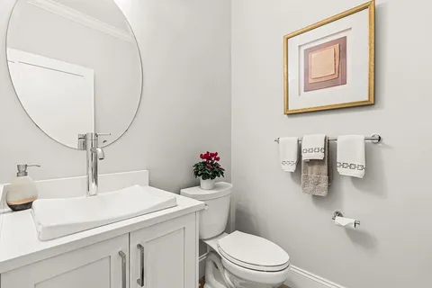 a bathroom with a sink mirror vanity and toilet
