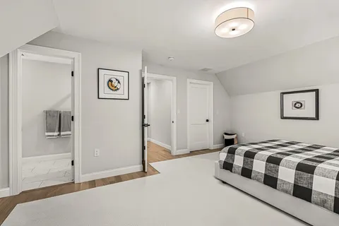 a bedroom with a bed and painting on the wall