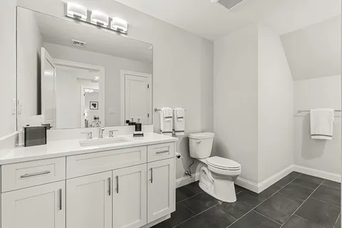 a bathroom with a double vanity sink mirror and toilet