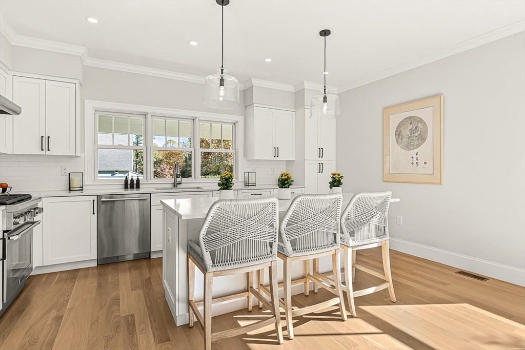 5 Peakes Lane, Unit 5 Weston, MA 02493 - Photo 4 of 32 a kitchen with stainless steel appliances granite countertop a sink a stove a refrigerator and island with wooden floor