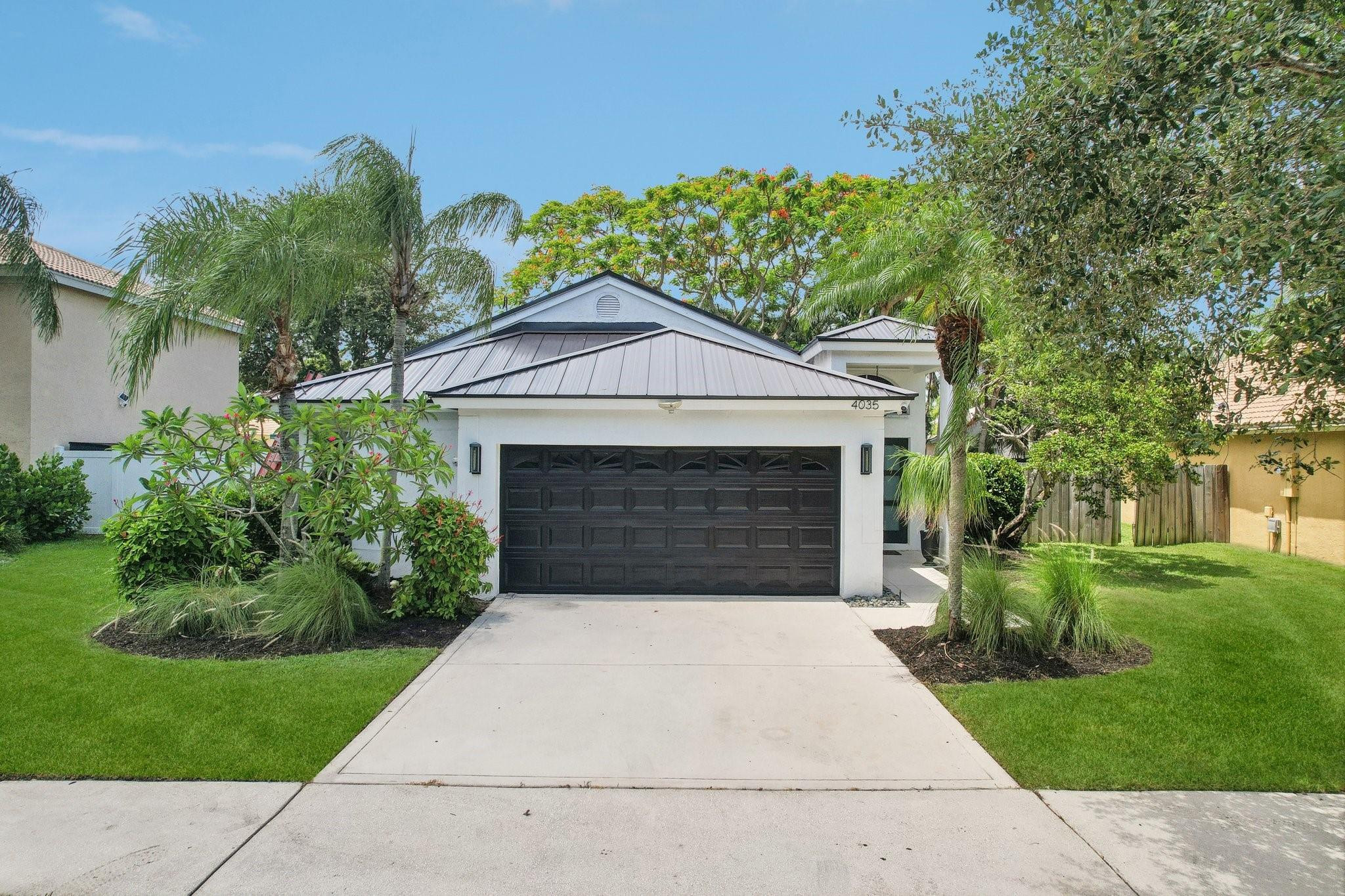 4035 Sabal Lakes Road Delray Beach, FL 33445 - Photo 1 of 43 a front view of a house with a yard
