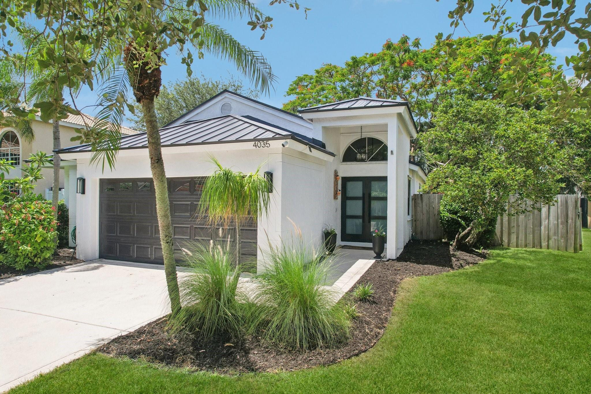 4035 Sabal Lakes Road Delray Beach, FL 33445 - Photo 2 of 43 a front view of a house with garden