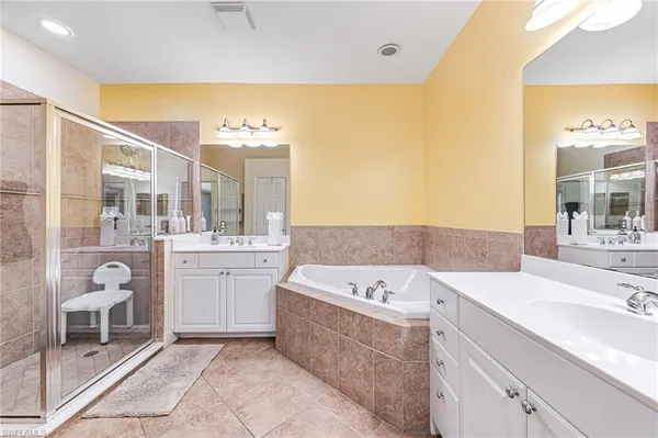 a bathroom with a tub sink and mirror