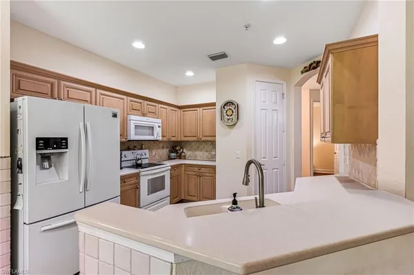 a kitchen with stainless steel appliances a refrigerator sink and cabinets
