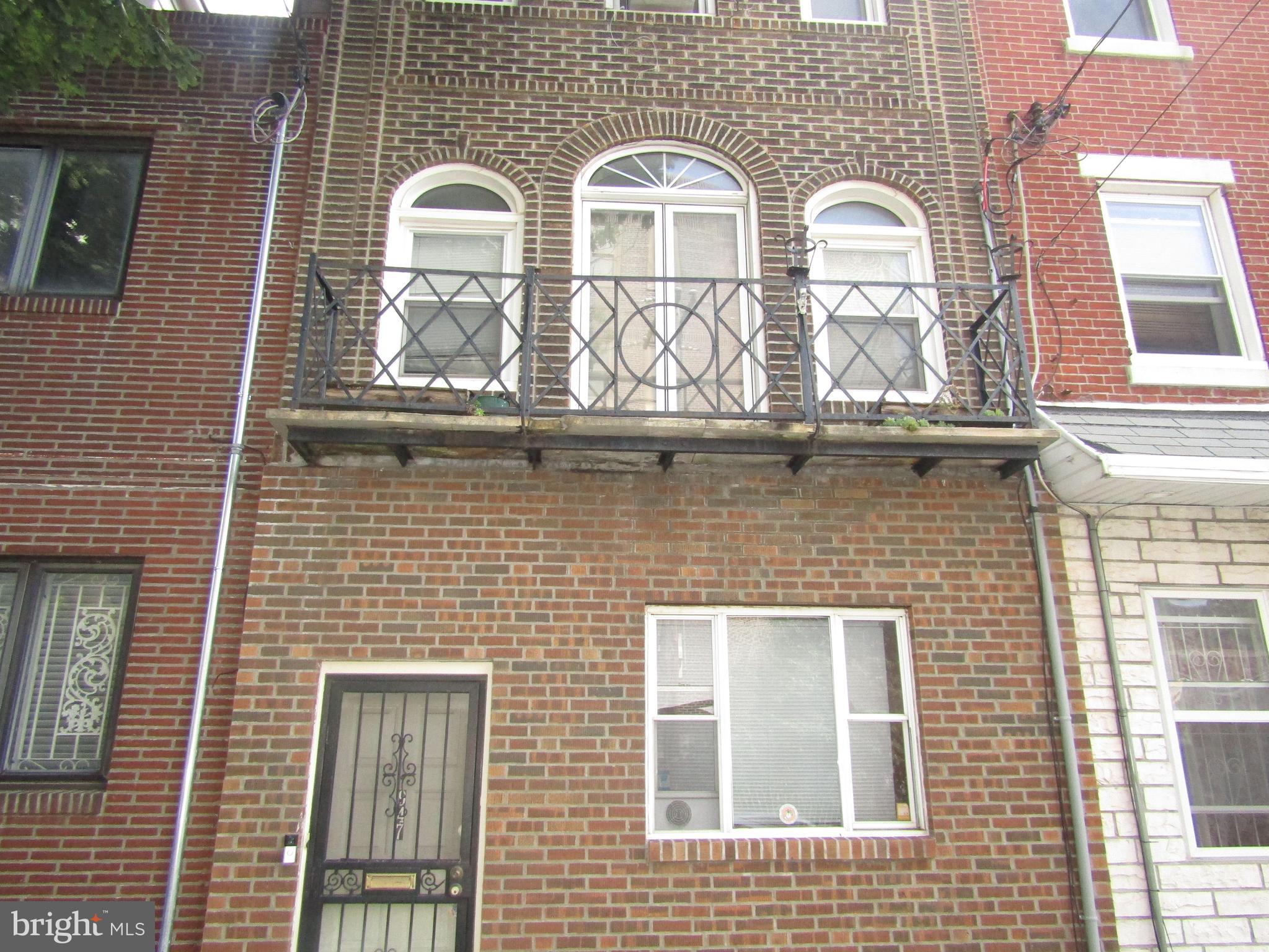 a view of two brick house with large windows