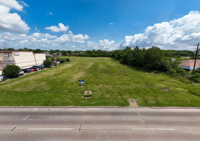 an aerial view of a tennis ground and a cars park side of the road