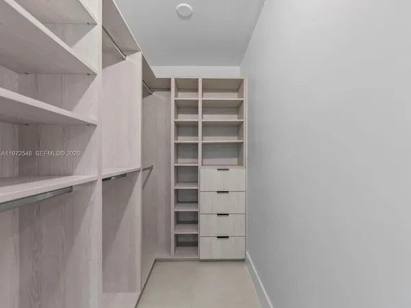 a view of walk in closet with empty racks