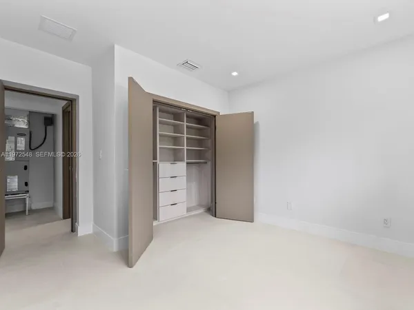 an empty room with closet and wooden door