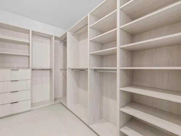 a view of walk in closet with empty racks
