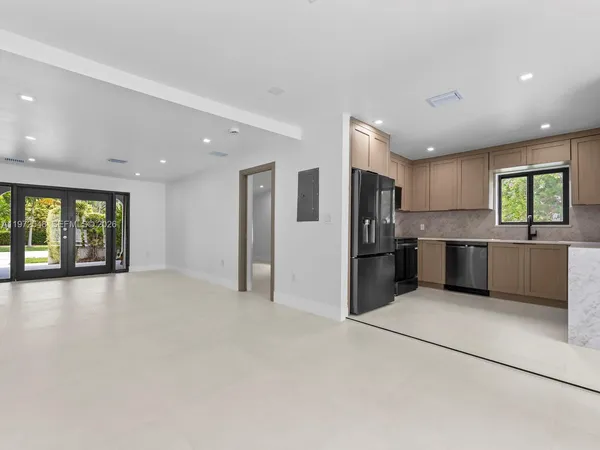 a view of kitchen with stainless steel appliances kitchen island granite countertop a refrigerator oven a sink with dishwasher and cabinets