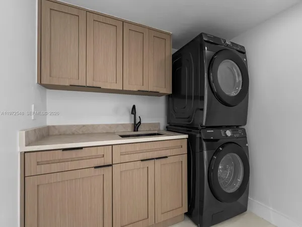 a utility room with sink dryer and washer