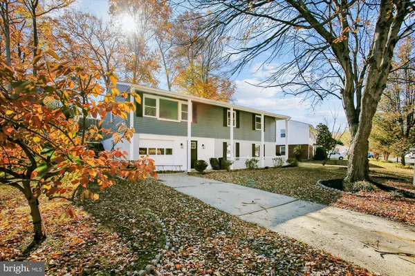 a front view of a house with a yard and tree s
