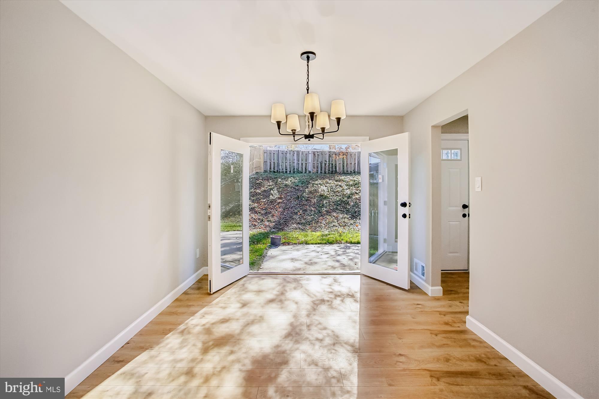 9075 Andromeda Drive Burke, VA 22015 - Photo 14 of 30 a view of a room with wooden floor chandelier and glass door