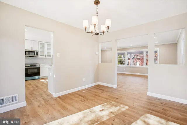 a view of a kitchen with a sink and dishwasher with wooden floor