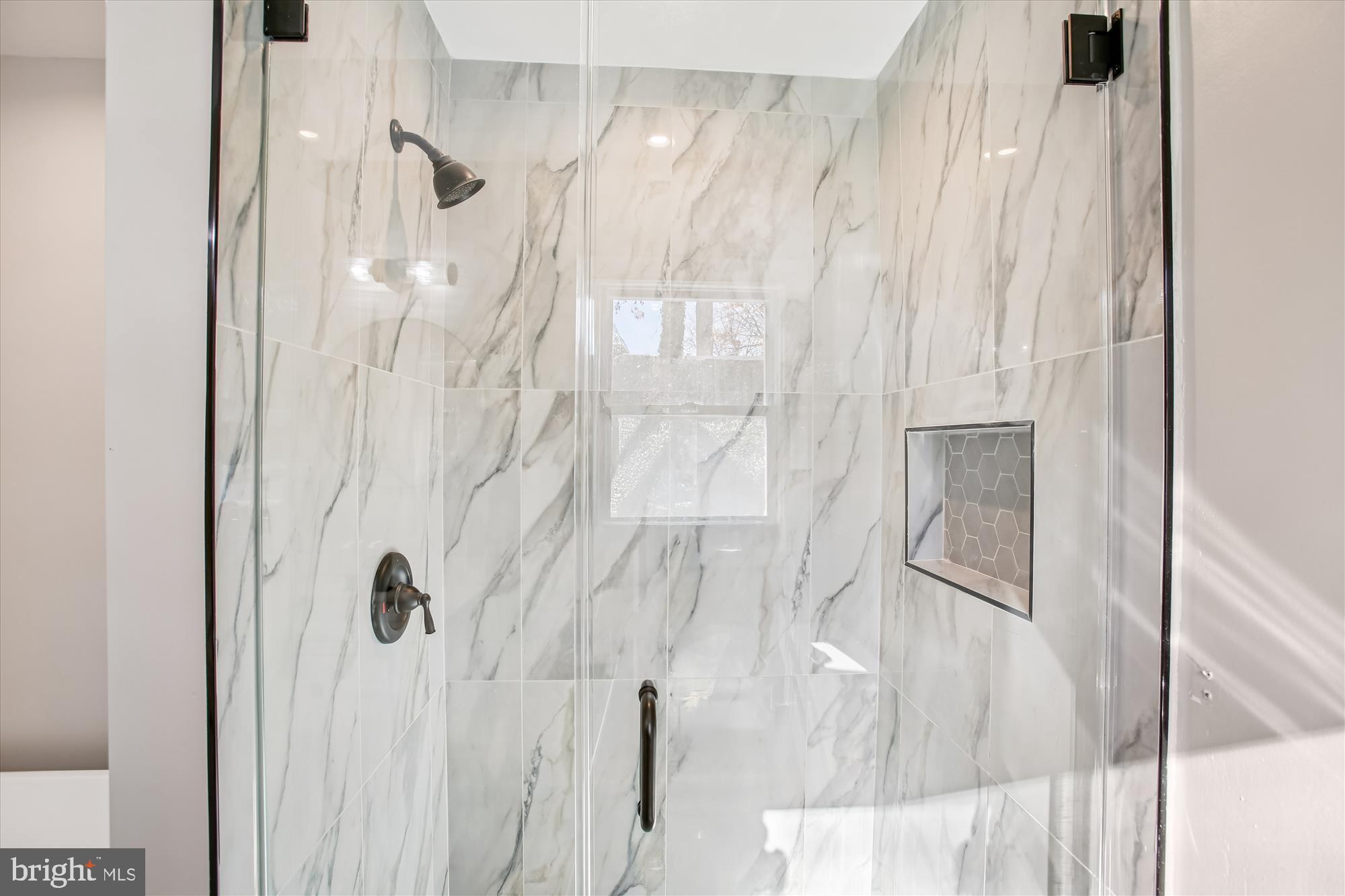 9075 Andromeda Drive Burke, VA 22015 - Photo 16 of 30 Elegant marble shower with modern fixtures.