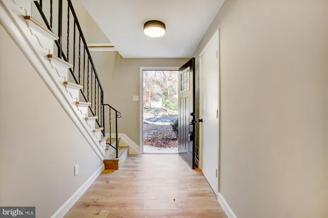 a view of hallway with wooden floor and stair