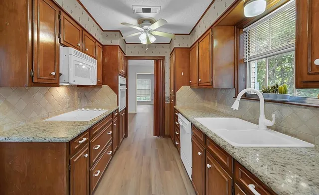 a kitchen with granite countertop a sink a counter top space and stainless steel appliances