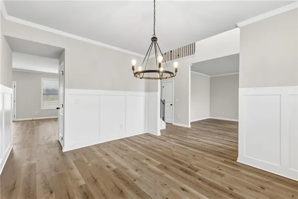 a view of a livingroom with wooden floor and a chandelier
