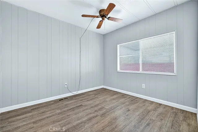 a view of room with hardwood floor and a ceiling fan