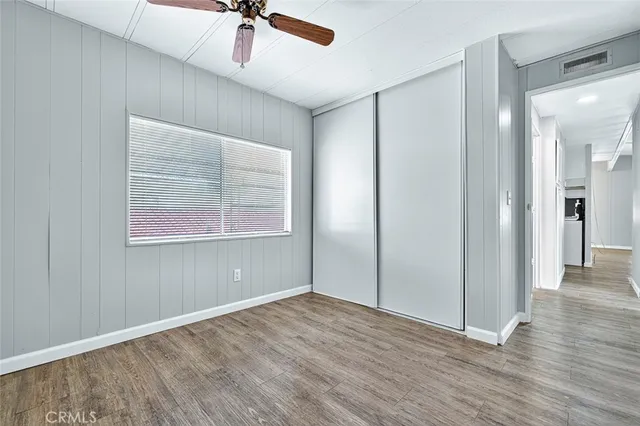 a view of a livingroom with wooden floor and a ceiling fan