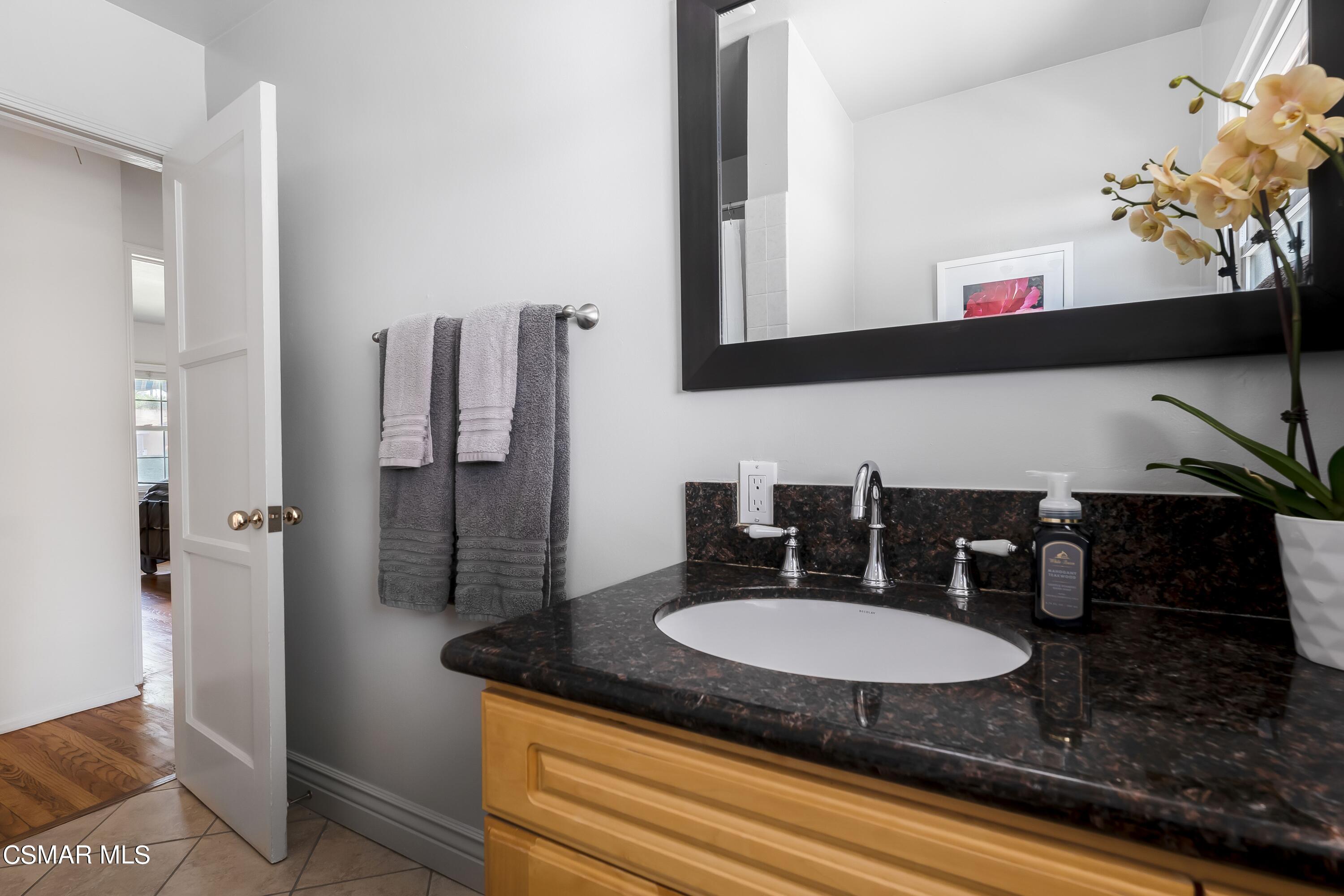 7247 Yolanda Avenue Reseda, CA 91335 - Photo 16 of 33 a bathroom with a granite countertop sink and a mirror