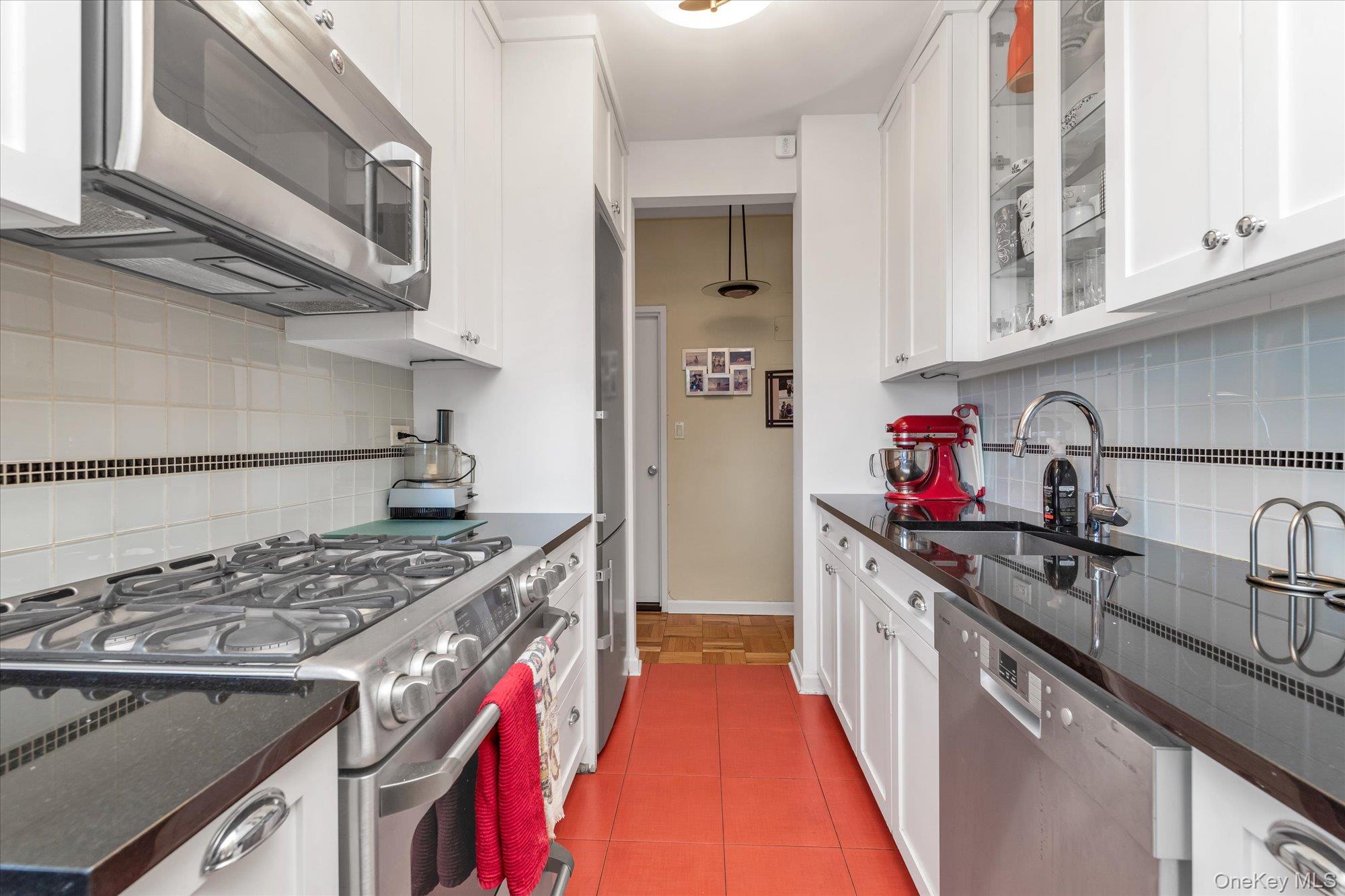 17-85 215th Street, Unit 17E Queens, NY 11360 - Photo 11 of 33 a kitchen with stainless steel appliances granite countertop a stove and a sink