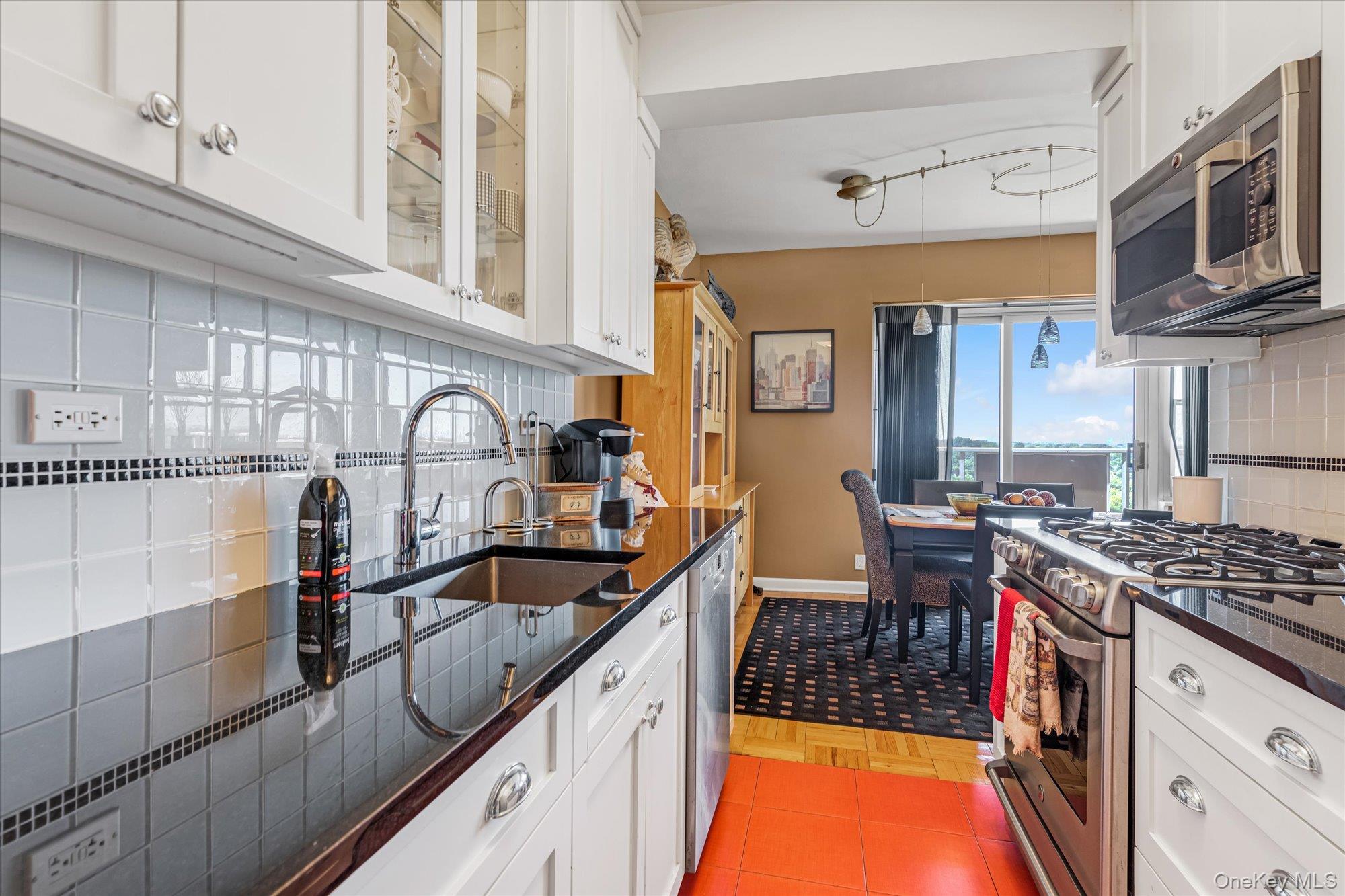17-85 215th Street, Unit 17E Queens, NY 11360 - Photo 12 of 33 a kitchen with stainless steel appliances granite countertop a sink stove and cabinets