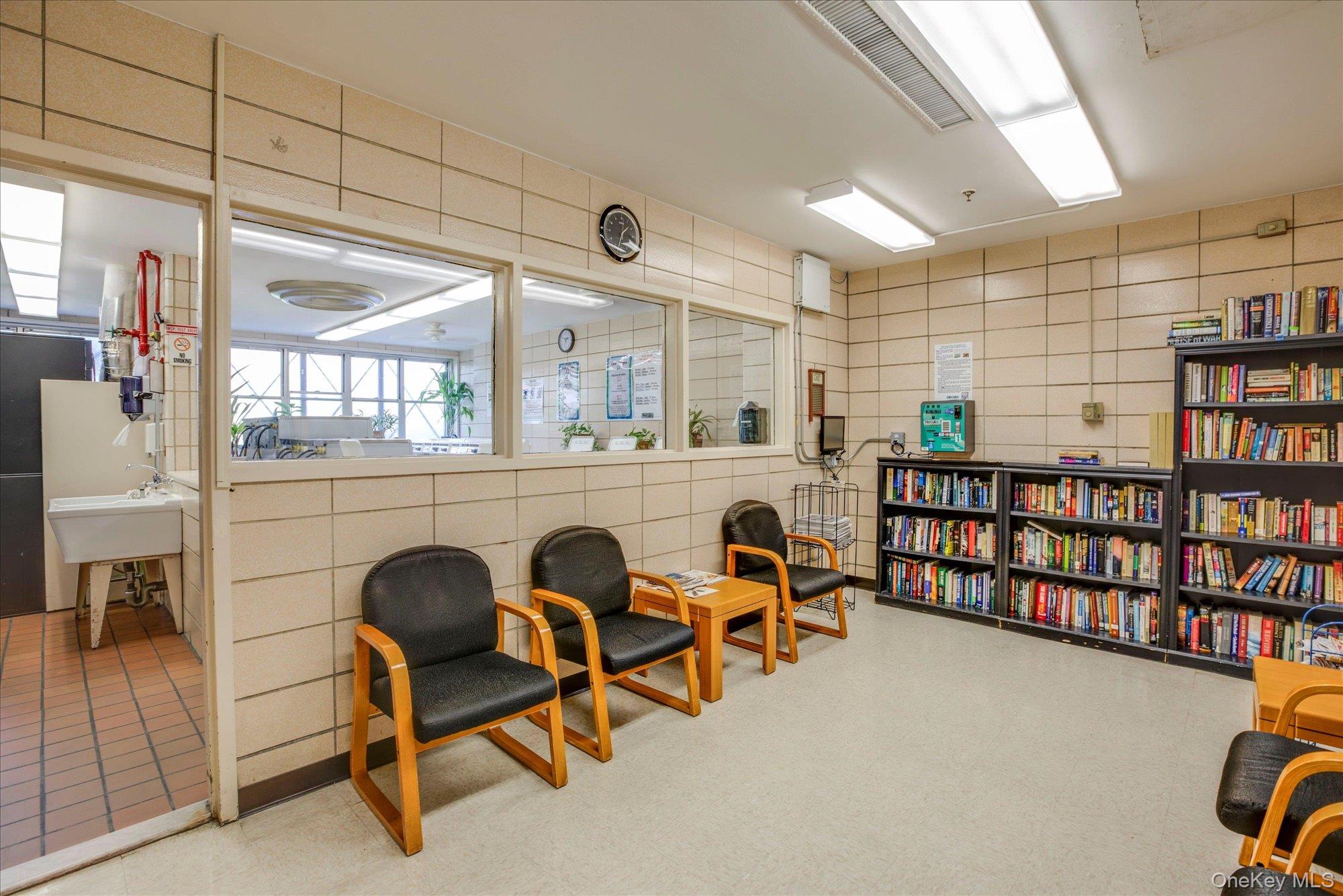 17-85 215th Street, Unit 17E Queens, NY 11360 - Photo 33 of 33 a living room with furniture a rug and a book shelf