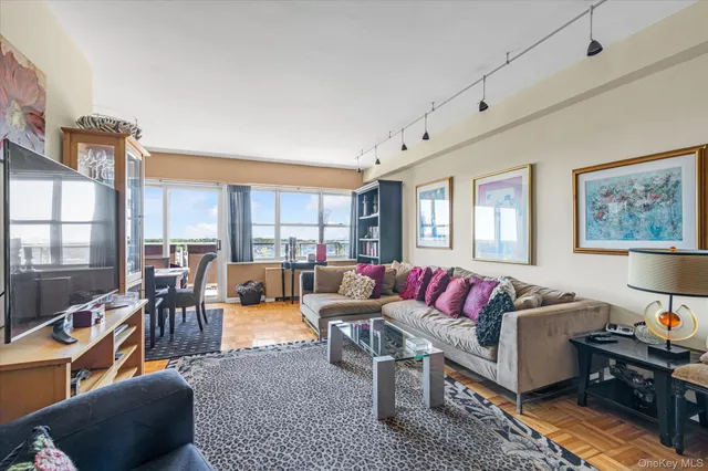 a living room with furniture kitchen view and a large window