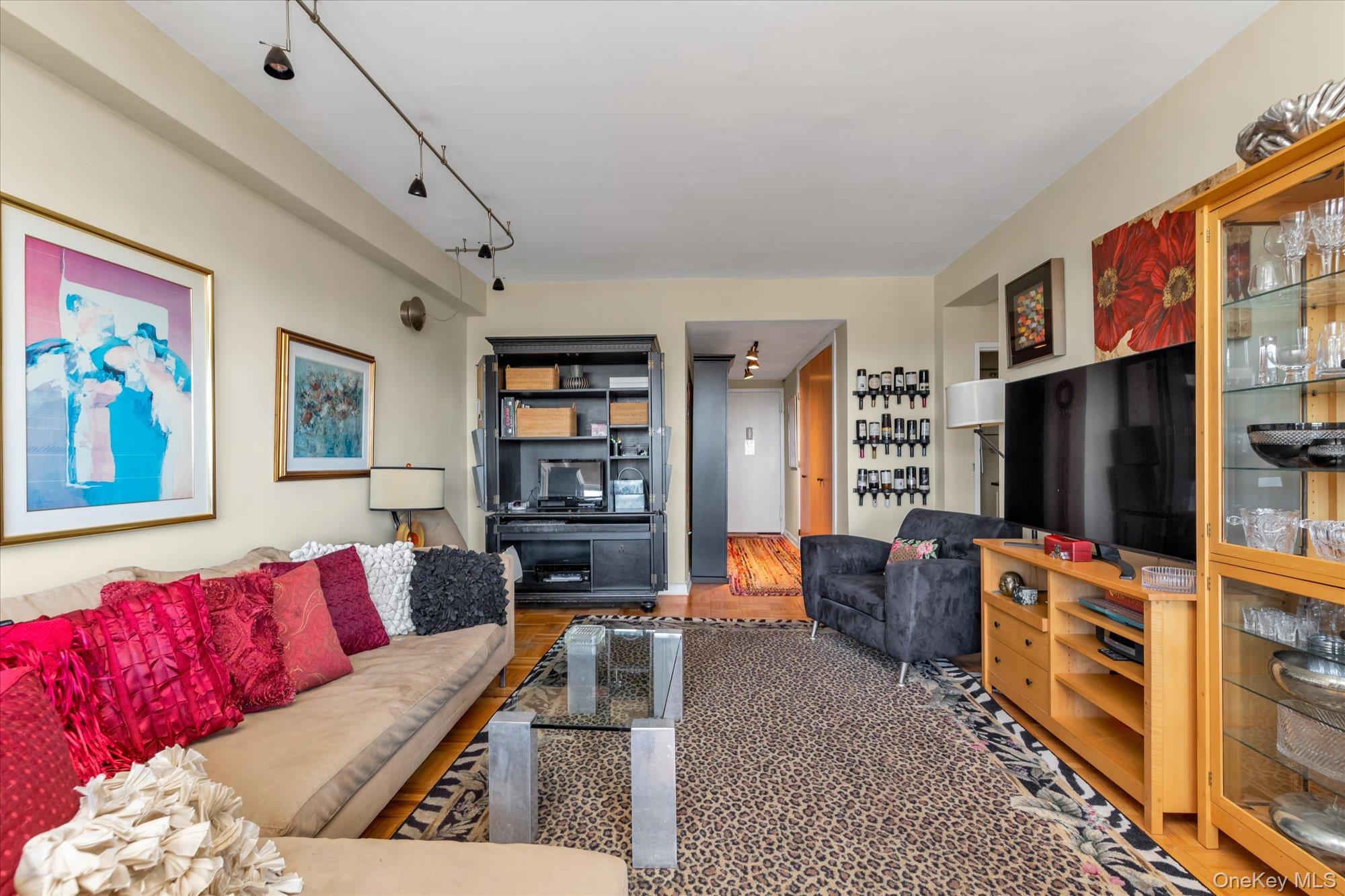 17-85 215th Street, Unit 17E Queens, NY 11360 - Photo 7 of 33 a living room with furniture and a flat screen tv