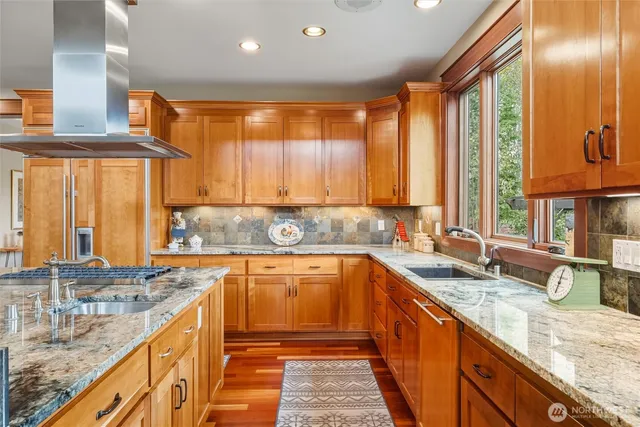 a large kitchen with granite countertop a sink and a large window