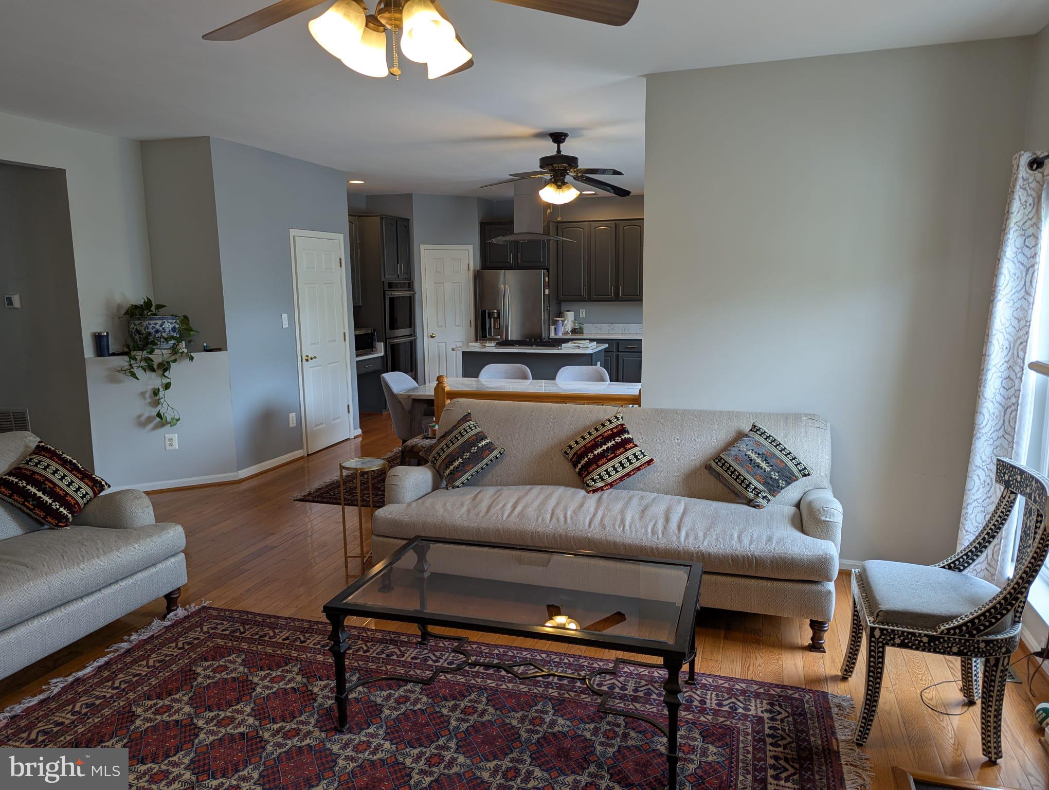 9871 Upper Mill Loop Bristow, VA 20136 - Photo 12 of 84 a living room with furniture a flat screen tv and kitchen view