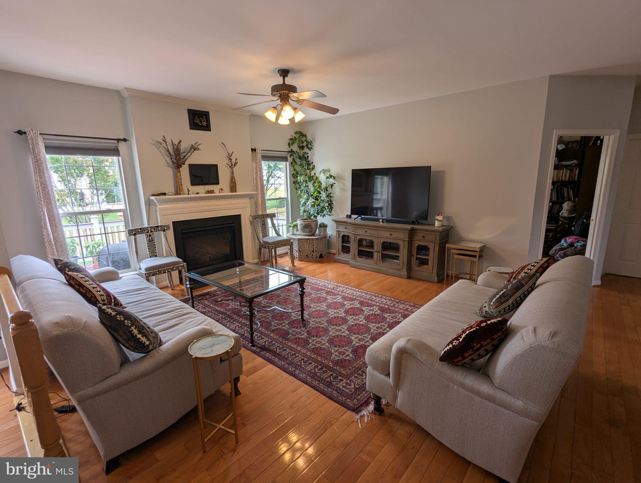 9871 Upper Mill Loop Bristow, VA 20136 - Photo 13 of 84 a living room with furniture a flat screen tv and a fireplace