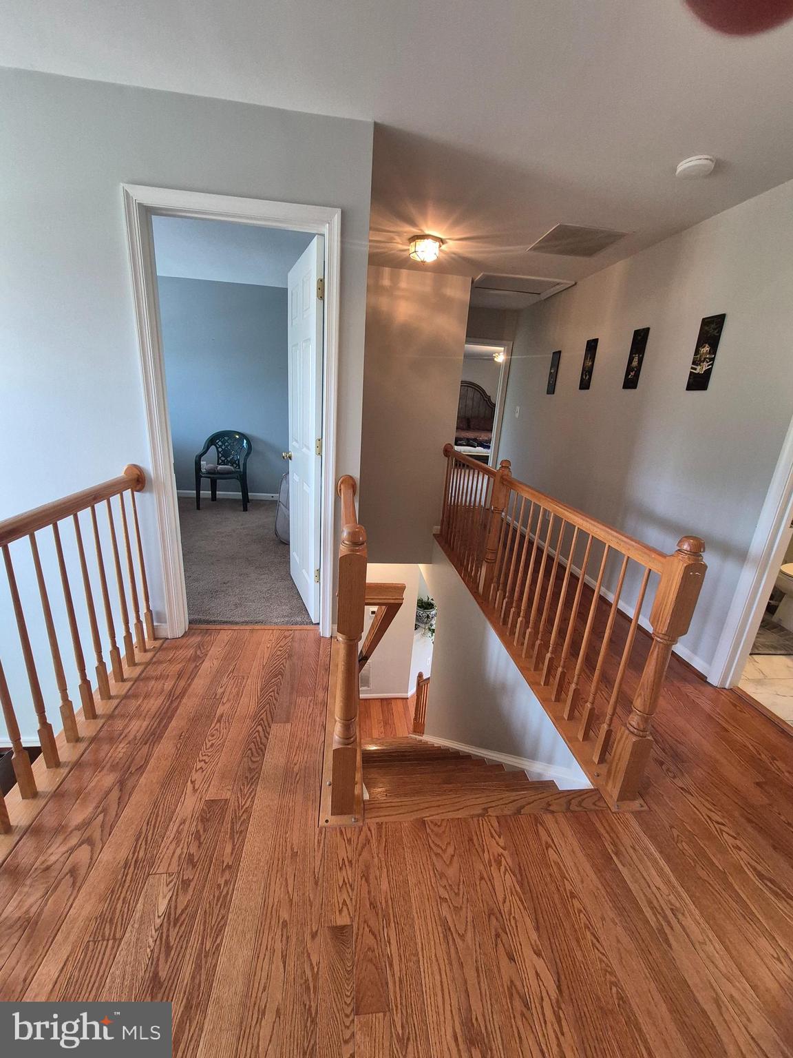 9871 Upper Mill Loop Bristow, VA 20136 - Photo 25 of 84 a view of a hallway with wooden floor and staircase