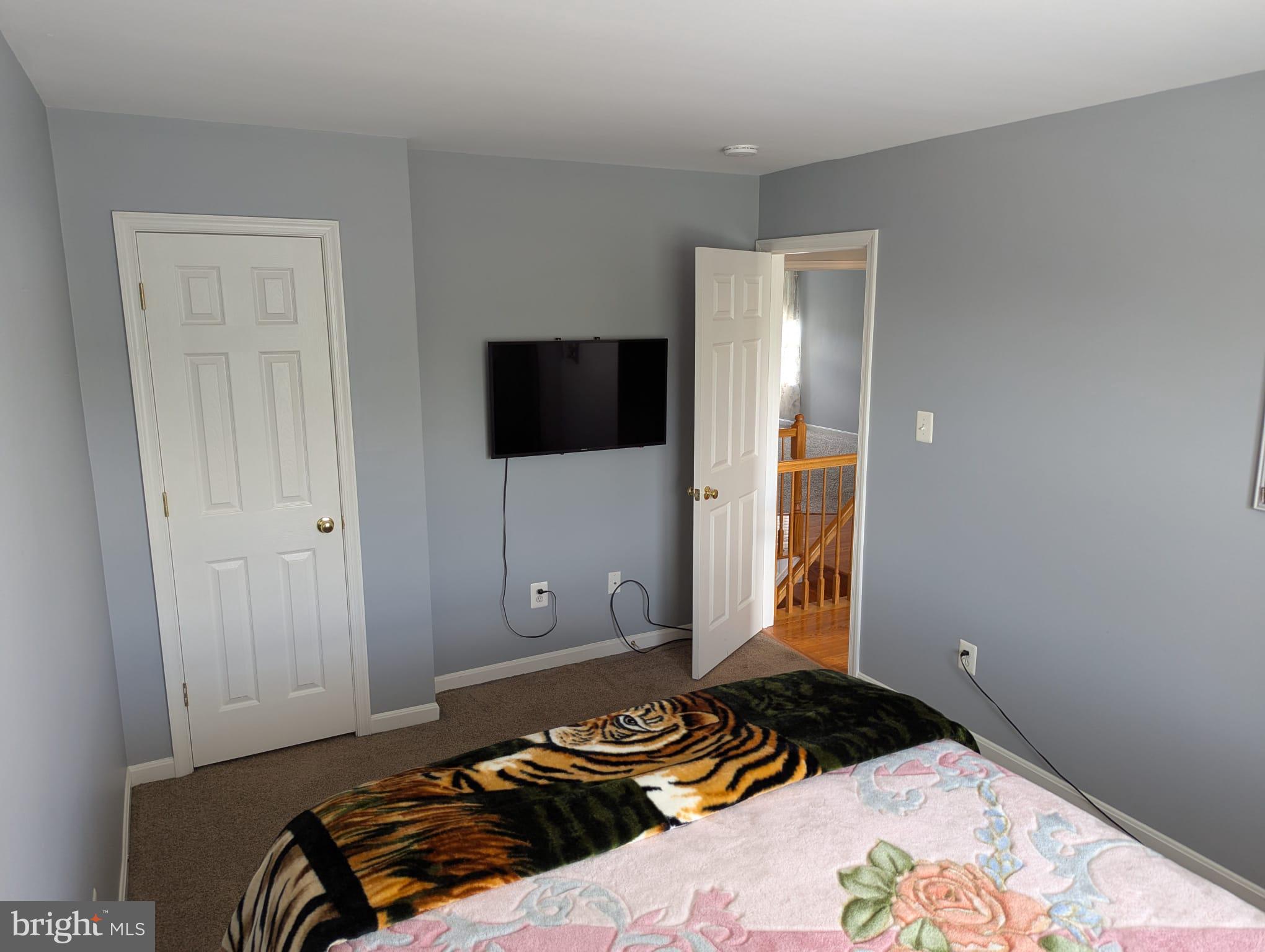 9871 Upper Mill Loop Bristow, VA 20136 - Photo 33 of 84 a bedroom with a bed and a flat tv screen on a dresser