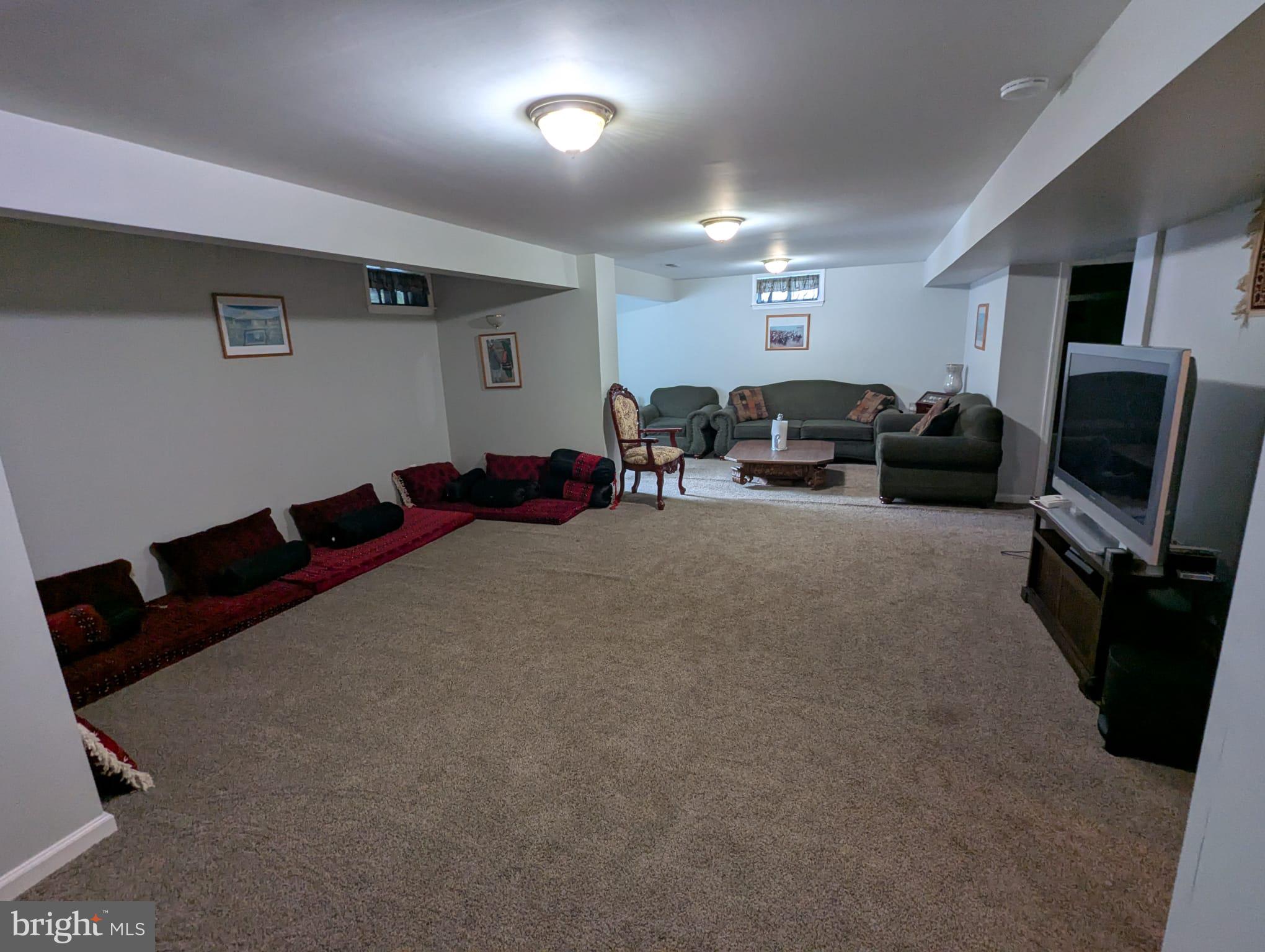 9871 Upper Mill Loop Bristow, VA 20136 - Photo 60 of 84 a living room with furniture gym equipment and a flat screen tv