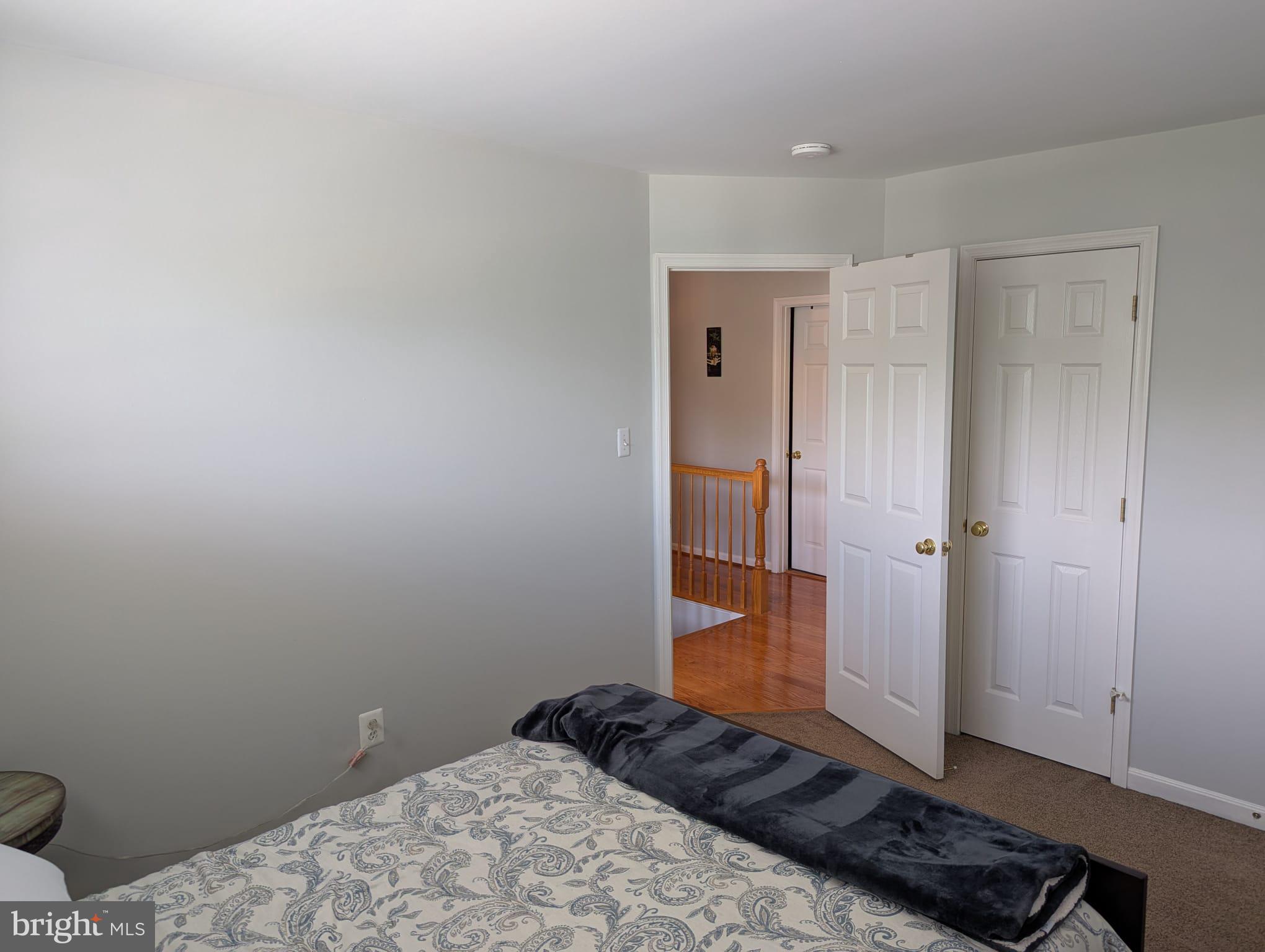 9871 Upper Mill Loop Bristow, VA 20136 - Photo 64 of 84 a bedroom with a bed and wooden floor