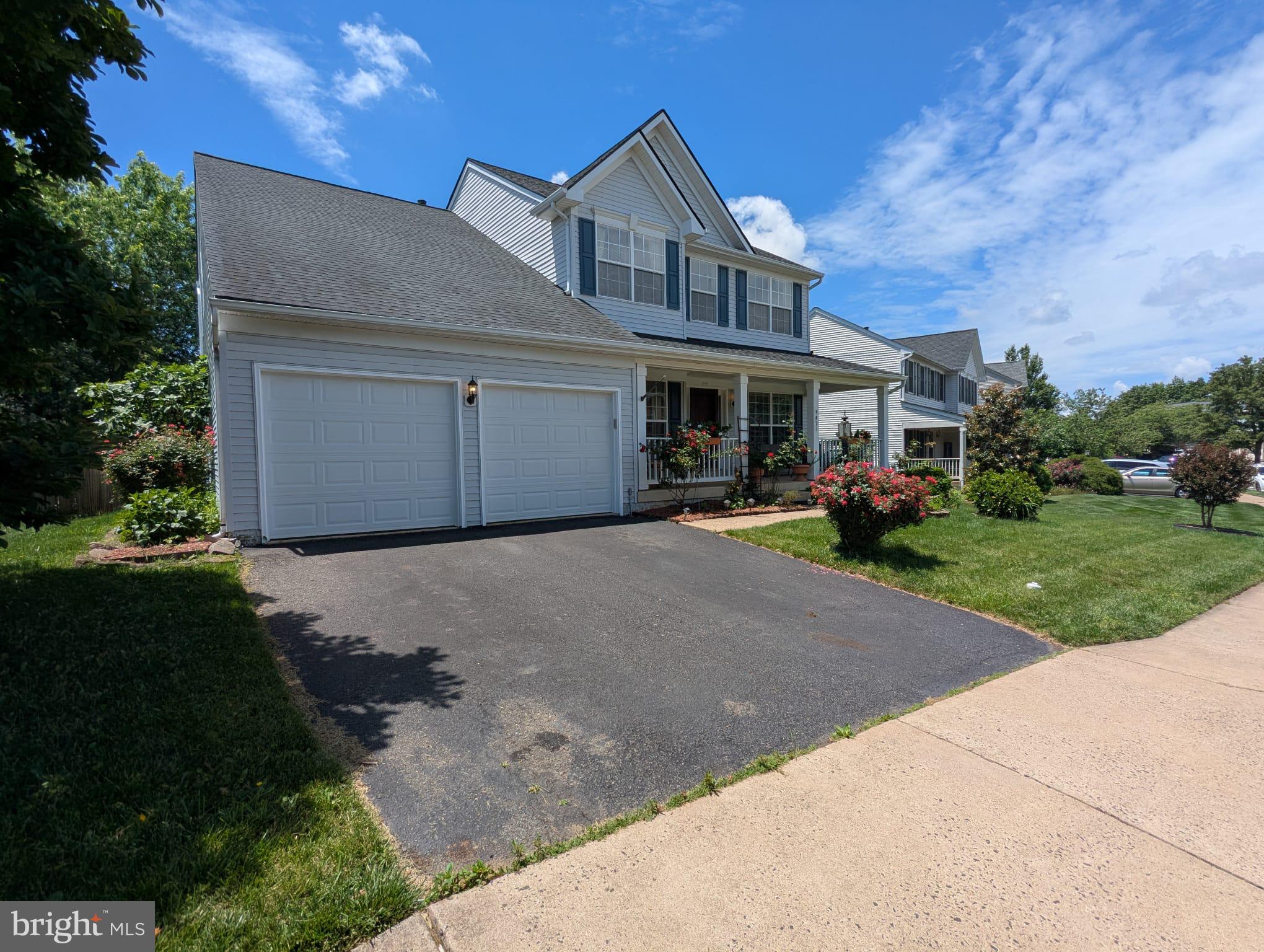 9871 Upper Mill Loop Bristow, VA 20136 - Photo 67 of 84 a front view of a house with a yard and garage