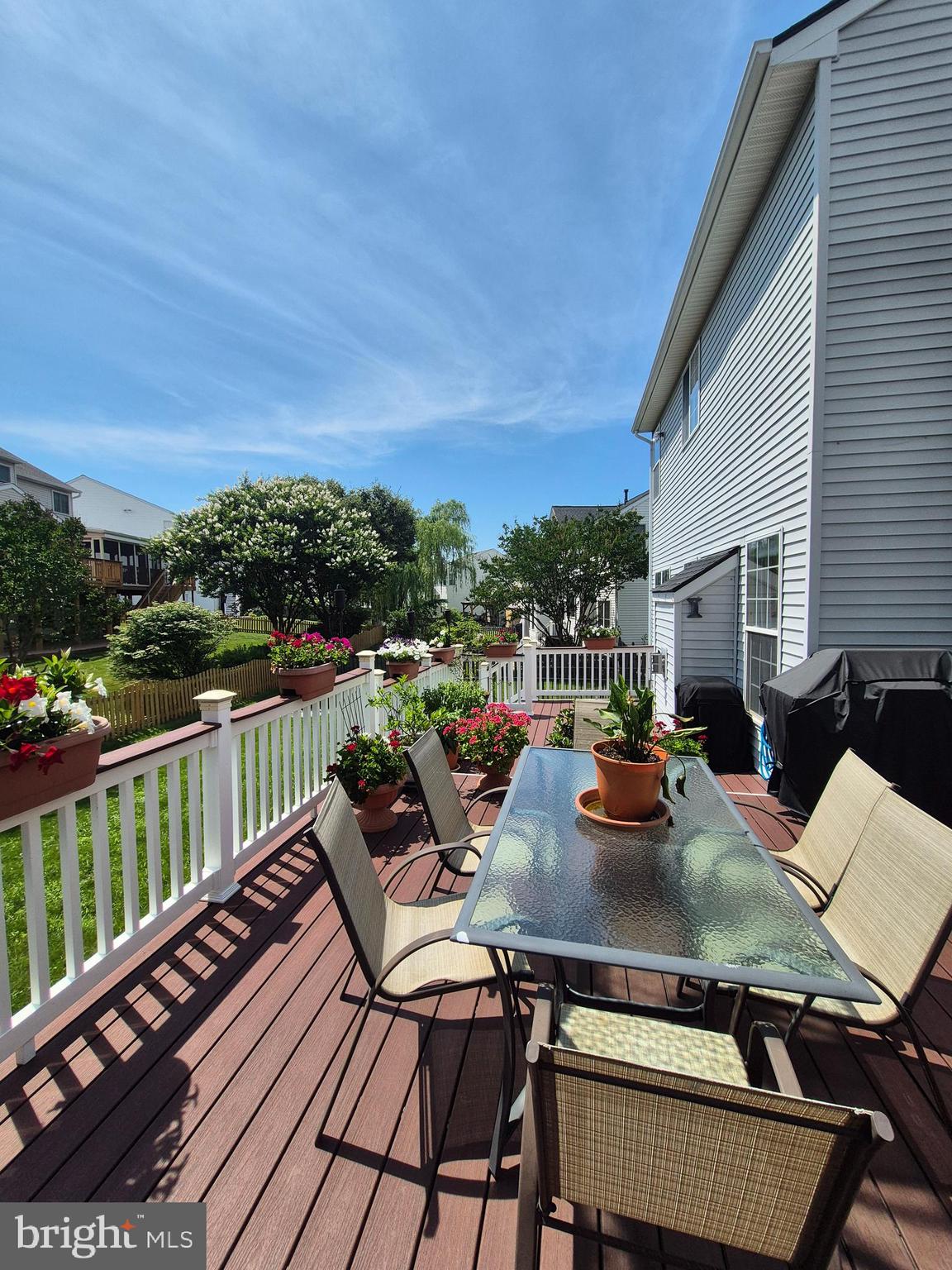 9871 Upper Mill Loop Bristow, VA 20136 - Photo 78 of 84 a view of a roof deck with dining table and chairs with wooden floor and fence