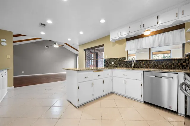 a spacious bathroom with a granite countertop sink a mirror and a bathtub