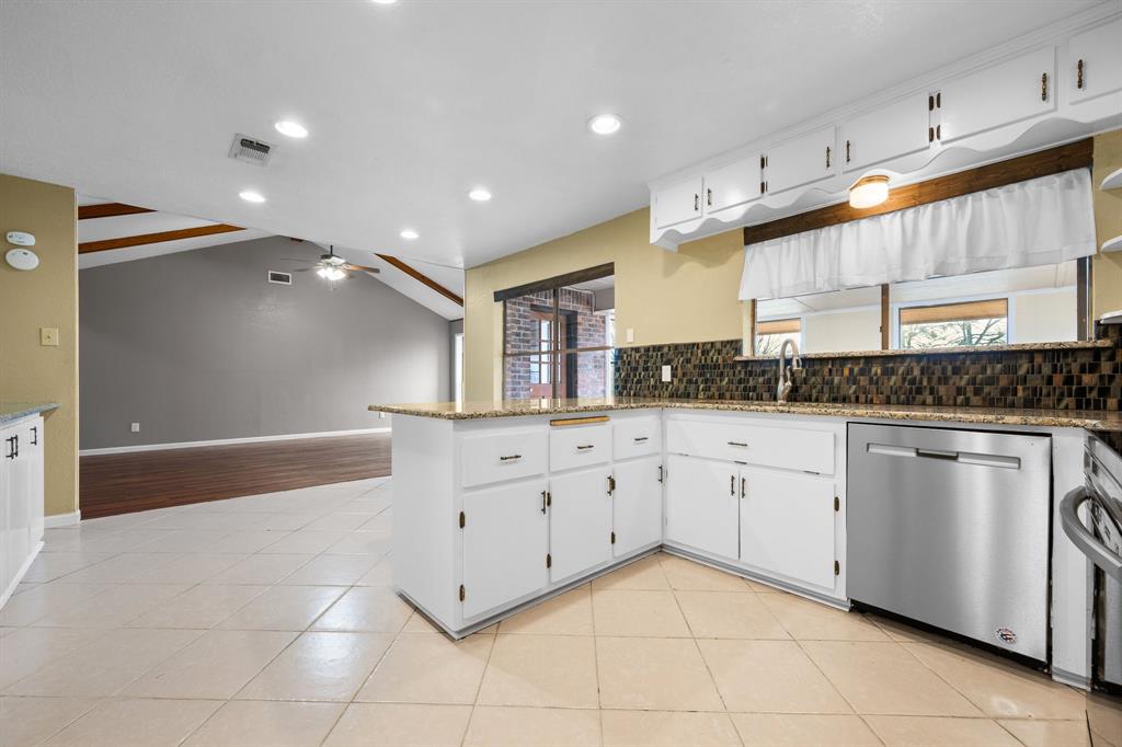 1102 Lena Street Cleburne, TX 76033 - Photo 12 of 36 a spacious bathroom with a granite countertop sink a mirror and a bathtub